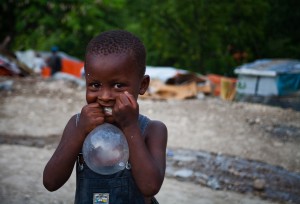 En dreng leger med et kondom i en af lejrene i Petionville, Port au Prince
